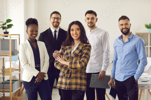 Happy smiling confident female hispanic businesswoman team leader standing together with diverse multiethnic business group in office. Company professional multinational staff portrait photo