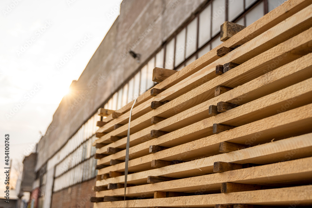 Storage of piles of wooden boards on the sawmill. Boards are stacked in a carpentry shop. Sawing drying and marketing of wood. Pine lumber for furniture production, construction. Lumber Industry. Storage of piles of wooden boards on the sawmill. Boards are stacked in a carpentry shop. Sawing drying and marketing of wood. Pine lumber for furniture production, construction. Lumber Industry.