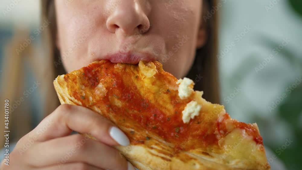Woman eating pizza. Close-up. Concept of quick bites and unhealthy food Woman eating pizza. Close-up. Concept of quick bites and unhealthy food