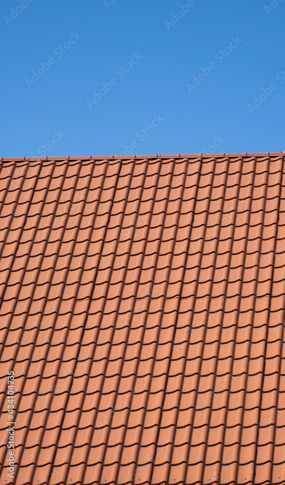 Red corrugated metal profile roof installed on a modern house. The roof of corrugated sheet. Roofing of metal profile wavy shape. Modern roof made of metal. Metal roofing. Red corrugated metal profile roof installed on a modern house. The roof of corrugated sheet. Roofing of metal profile wavy shape. Modern roof made of metal. Metal roofing.