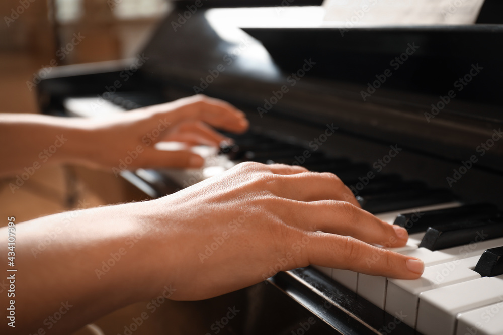 Obraz premium Young woman playing piano, closeup. Music lesson