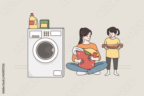 Laundry and spending time with children concept.Young smiling happy woman and her small daughter cartoon characters sitting on floor preparing dirty clothes for washing together vector illustration 