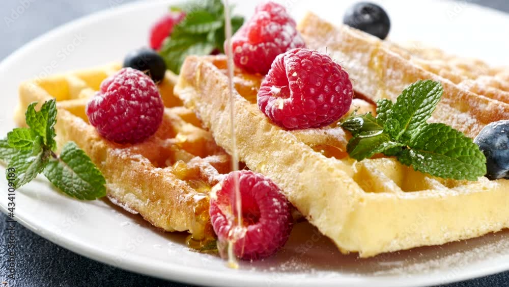 waffles with berries fruits and syrup pouring waffles with berries fruits and syrup pouring