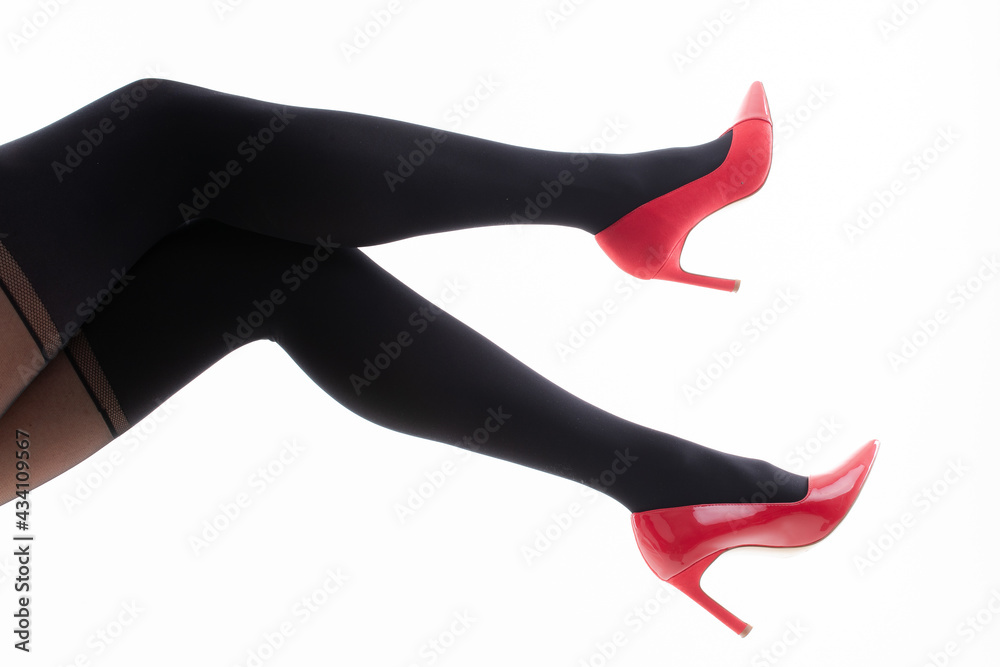 Feet of a girl in pantyhose with red shoes on a white background Feet of a girl in pantyhose with red shoes on a white background