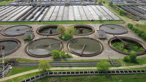 Aerial shot of a wastewater treatment plant and distant skyline. Big city waste processing concept