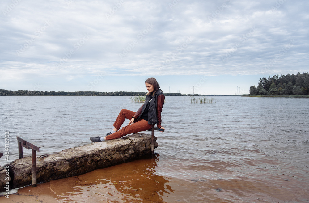 young woman near the water river horizon autumn water body of water leather j young woman near the water river horizon autumn water body of water leather j