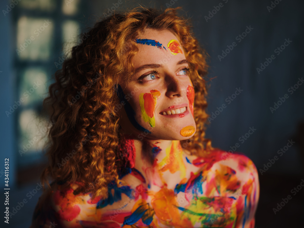 Red-haired girl with paints on her face and body