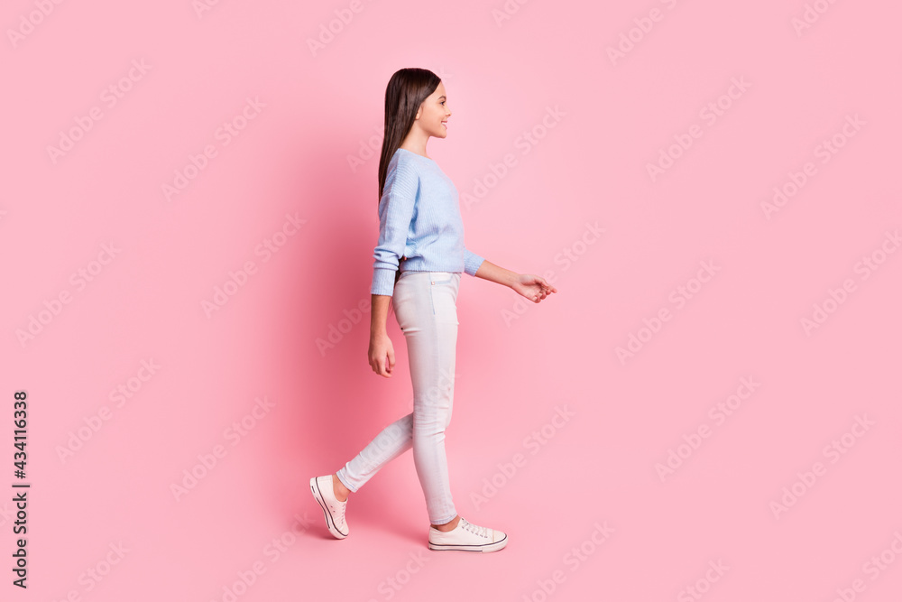 Full length body size profile side view of attractive cheerful girl walking isolated over pink pastel color background