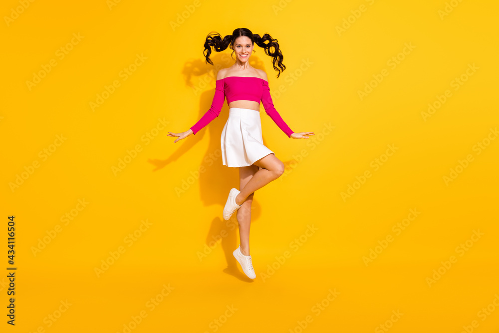 Full size photo of optimistic lovely brunette lady jump wear pink top skirt isolated on yellow background Full size photo of optimistic lovely brunette lady jump wear pink top skirt isolated on yellow background