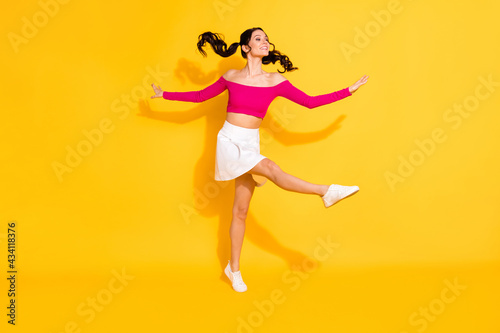 Full body profile side photo of young cheerful girl happy positive smile have fun enjoy isolated over yellow color background