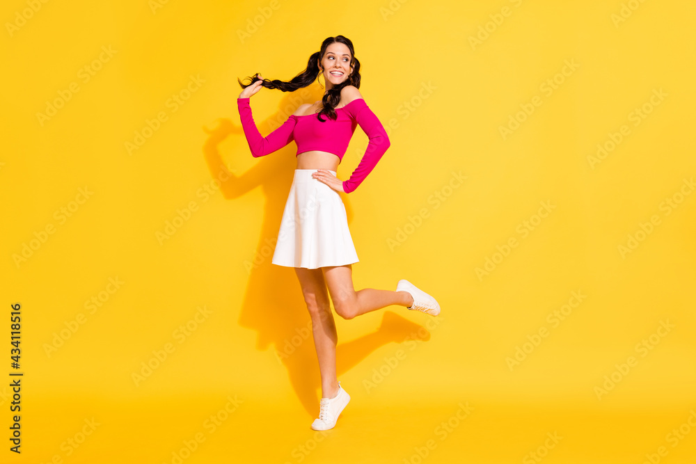 Full length body size view of attractive cheerful thin wavy-haired girl posing having fun good mood isolated over bright yellow color background Full length body size view of attractive cheerful thin wavy-haired girl posing having fun good mood isolated over bright yellow color background