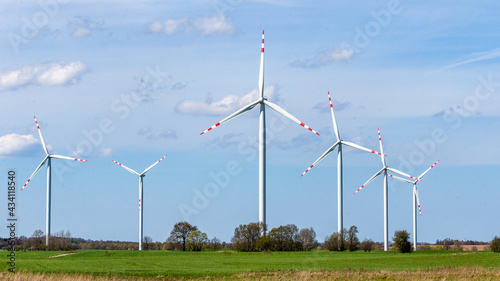 wind turbine in the wind against the backdrop of blue sky with clouds