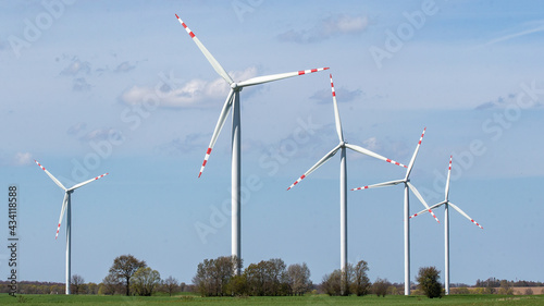 wind turbine in the wind against the backdrop of blue sky with clouds