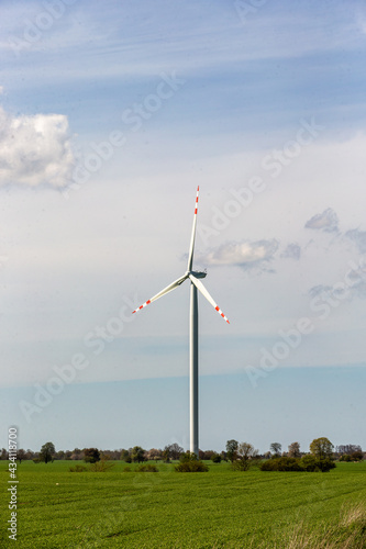 wind turbine in the wind against the backdrop of blue sky with clouds