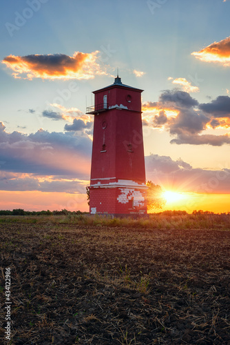 Khablovskiy lighthouse standing in the field at sunset, scenic landscape. Unique lighthouse on the border of Kherson and Mykolaiv region, Urkraine. Outdoor travel background with colorful dramatic sky