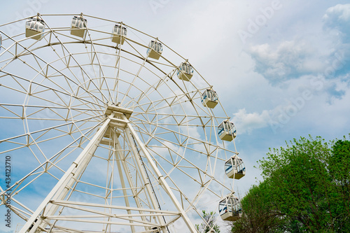 Ferris wheel in the park against the blue sky. Sokolniki Amusement Park in Moscow