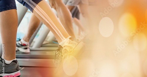 Composition of woman's leg with bones showing exercising on treadmill with spots of light
