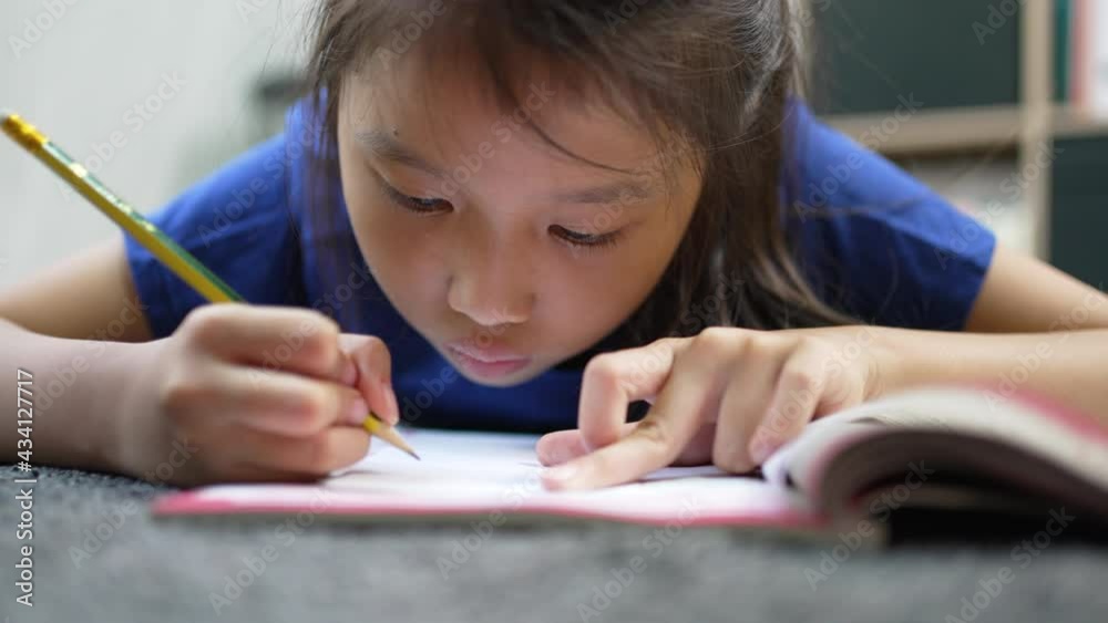Asian beautiful pupil writing at desk at home a homeschooling learning during covid-19 pandamic Asian beautiful pupil writing at desk at home a homeschooling learning during covid-19 pandamic