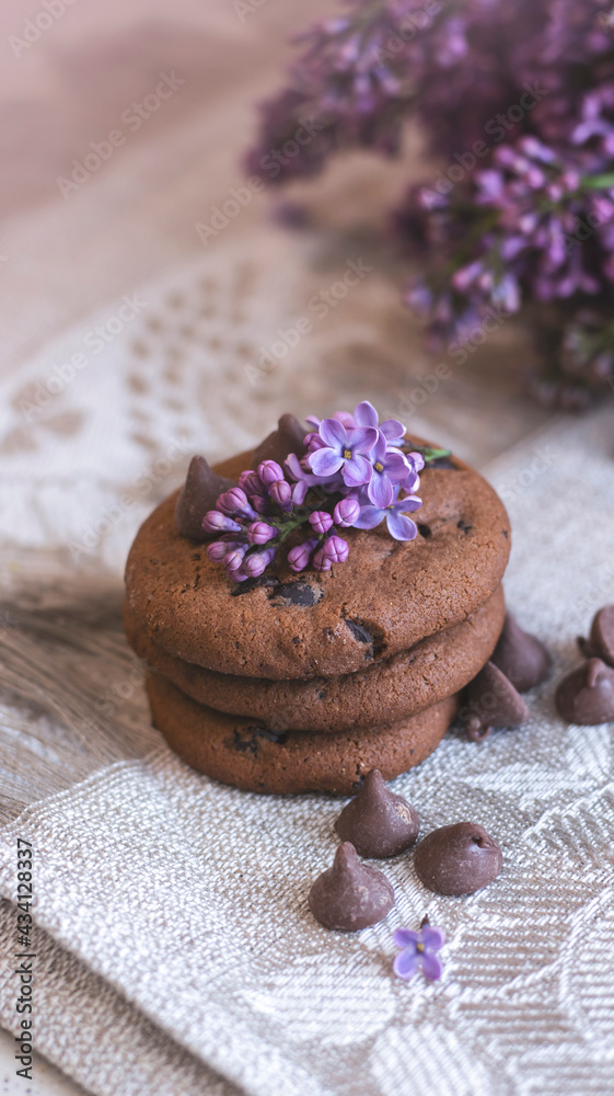 Decorative composition with a Bouquet of lilacs. Clay cup of tea and chocolate cake. A bouquet of lilacs in a vase. Spring floral background with lilacs in the interior. Decorative composition with a Bouquet of lilacs. Clay cup of tea and chocolate cake. A bouquet of lilacs in a vase. Spring floral background with lilacs in the interior.