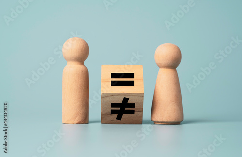 Flipping of unequal to equal sign between man and woman wooden figure. Human and business right concept. photo