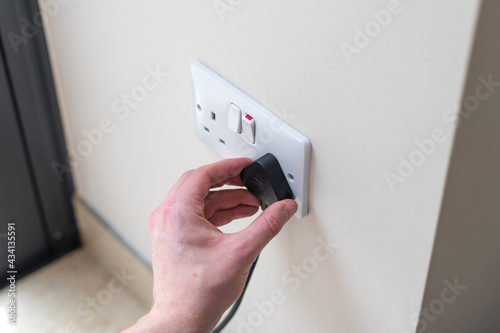 Schilderij op canvas White Uk plug sockets being unplugged to save electricity and money for the hous
