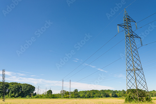 Fotografia High voltage electricity pylons in the rural agricultural fields outside Milan, Italy