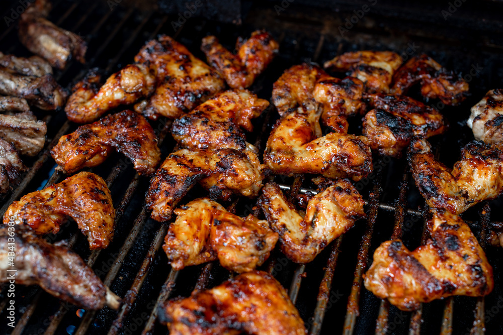 Bbq chicken wings on a barbecue grill cooking with a nice chargrilled finish, shallow depth of field advertising image Bbq chicken wings on a barbecue grill cooking with a nice chargrilled finish, shallow depth of field advertising image