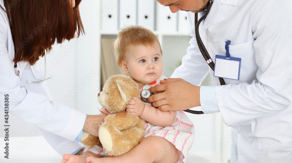 Happy smiling girl-child at usual medical inspection. Doctor and female toddler patient in the clinic. Medicine, healthcare concepts Happy smiling girl-child at usual medical inspection. Doctor and female toddler patient in the clinic. Medicine, healthcare concepts