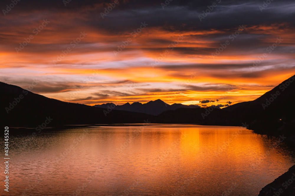 Gorgeous colorful sunset with pink, purple and orange clouds above the Medicine Lake
