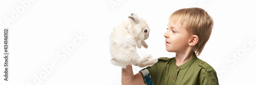 Little pretty boy holding fur rabbit baby. White cute pet at studio. Happy easter hug. Male person hand. Young people.