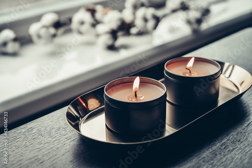 Burning candles on golden tray photo