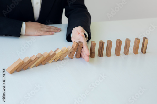 Businesswoman protect wooden block fall to planning and strategy in risk to business Alternative and prevent. Investment Insurance ,Business risk control concept,