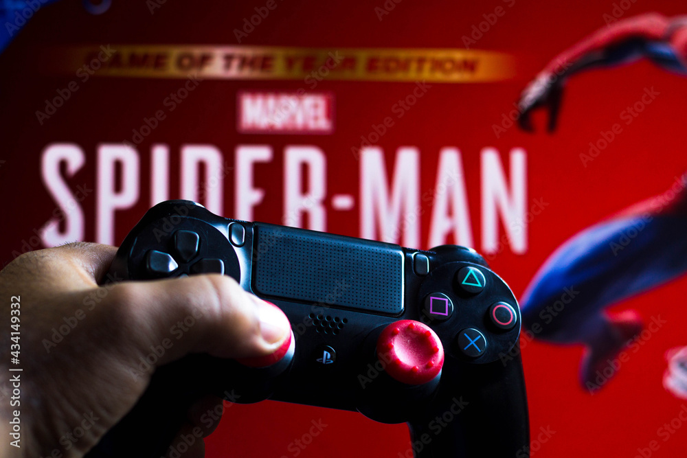 Obraz premium May 17, 2021, Brazil. In this photo illustration the controller for PlayStation (PS) and in the background the game logo Spider-Man.