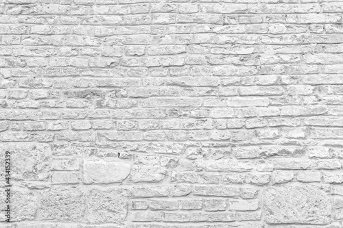 Old grungy retro bright brick wall of ancient city. Uneven clear pitted peeled surface brickwork of cellar worn. Ruined solid bumpy stiff blocks. Hard beautiful brickwall for 3D grunge minimal design