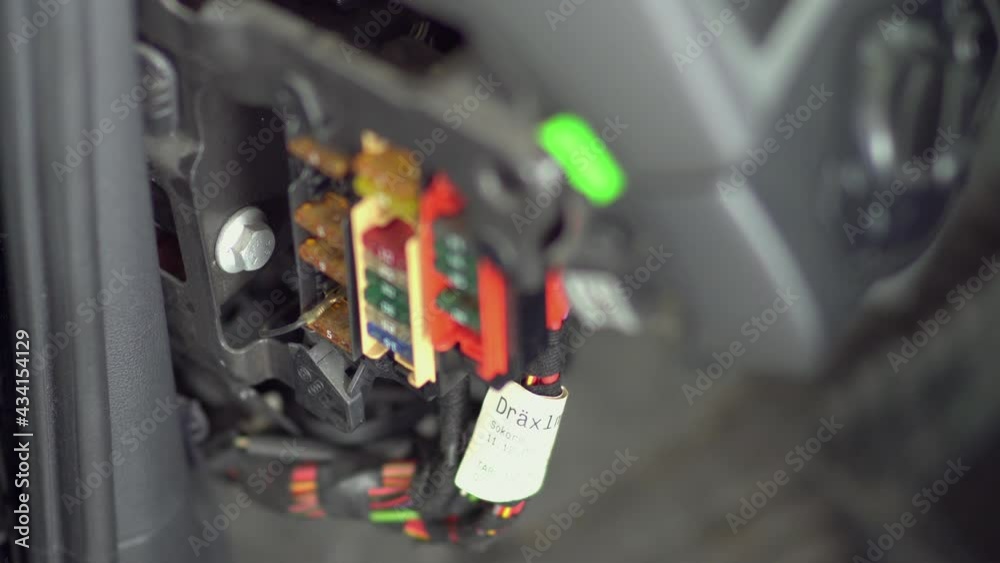 Replacing the fuse in fuse box of the car in a mechanic shop, closeup