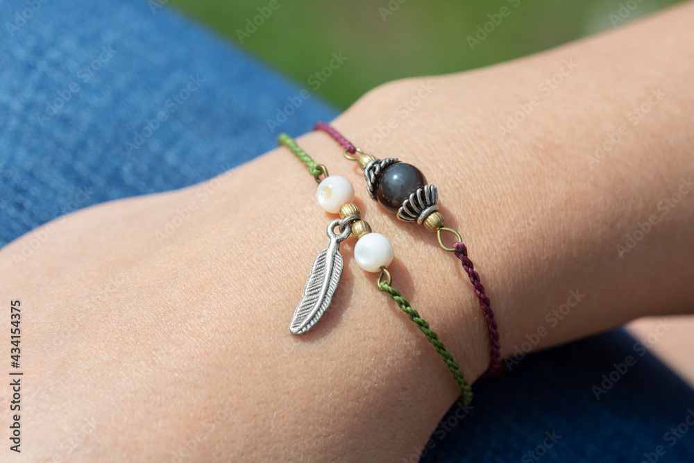 Obraz premium Female hand wearing popular gemstone mineral bead yoga bracelets