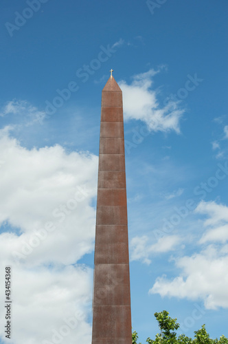 Iron obelisk with a small cross on a street in Madrid. Spain