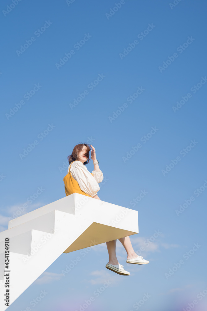 asian woman sit on white stair in flower garden on springtime vacation asian woman sit on white stair in flower garden on springtime vacation