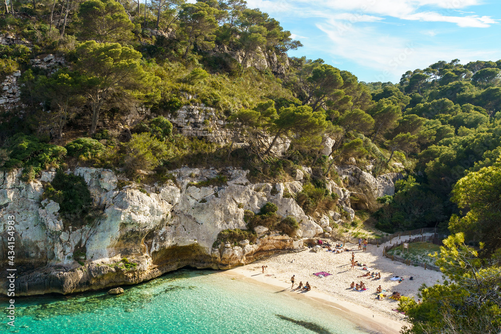 Panoramic view of Cala Macarelleta, with turquoise waters and blue sky, in Menorca, Balearic Islands, Spain