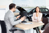 Salesperson selling cars at car dealership.
