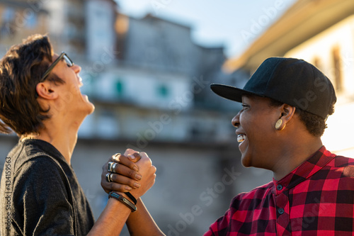 Two young men sharing a good joke laughing together photo