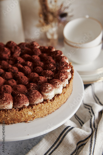 Vertical shot of a delicious Bonafi Cream Pie with chocolate powder on a beautifully decorated table photo