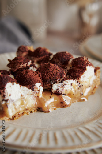 Closeup shot of delicious Bonafi Cream Pie slice with chocolate powder on a white plate photo