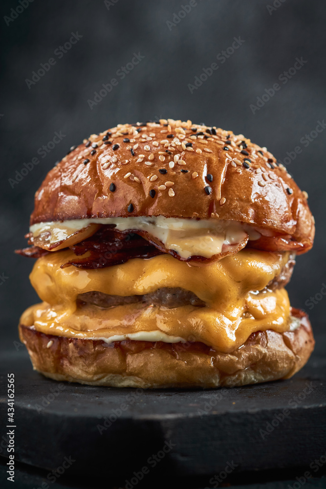 Vertical shot of a delicious double cheeseburger on a blackboard