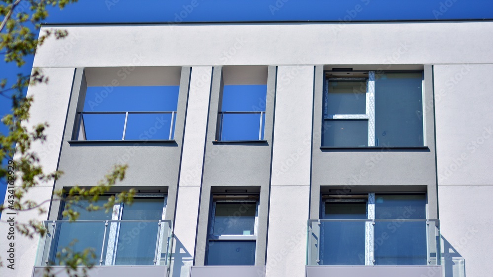 Condominium and apartment building with symmetrical modern architecture. Detail in modern residential flat apartment building exterior. Fragment of new luxury house and home complex. Condominium and apartment building with symmetrical modern architecture. Detail in modern residential flat apartment building exterior. Fragment of new luxury house and home complex.