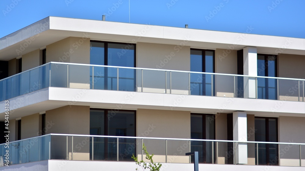 Condominium and apartment building with symmetrical modern architecture. Detail in modern residential flat apartment building exterior. Fragment of new luxury house and home complex. Condominium and apartment building with symmetrical modern architecture. Detail in modern residential flat apartment building exterior. Fragment of new luxury house and home complex.