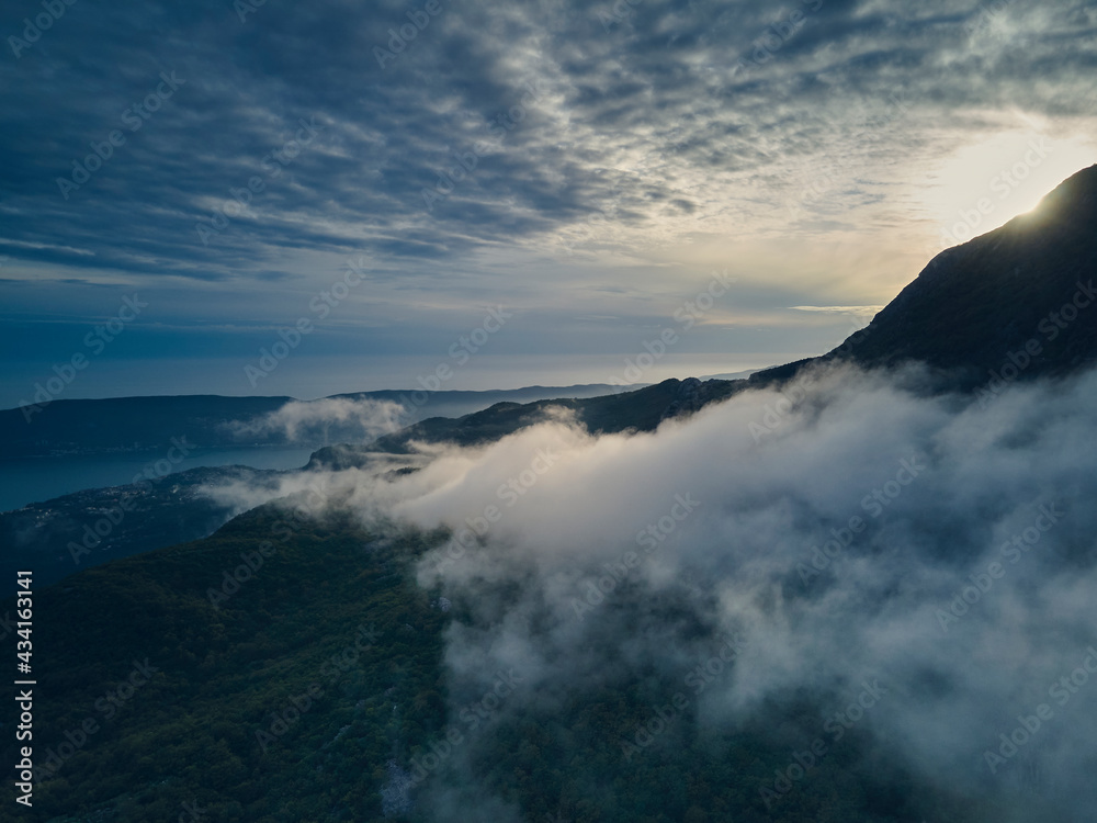 Panoramic view of the foggy entrance to the Bay of Kotor, Herceg Novi, Montenegro, with the mountains at sunset. 