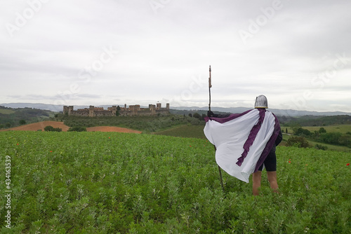 Il cavaliere con elmo e mantello davanti al castello medioevale  photo