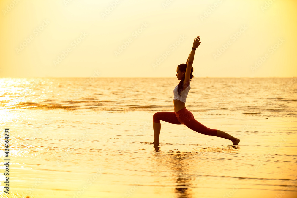 Healthy woman workout yoga pose in the beach at sunset. Concept Lifestyle Female People Vacations in Summer.