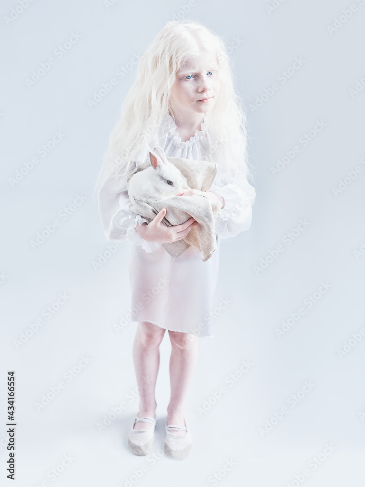 Girl with white hair holding a rabbit